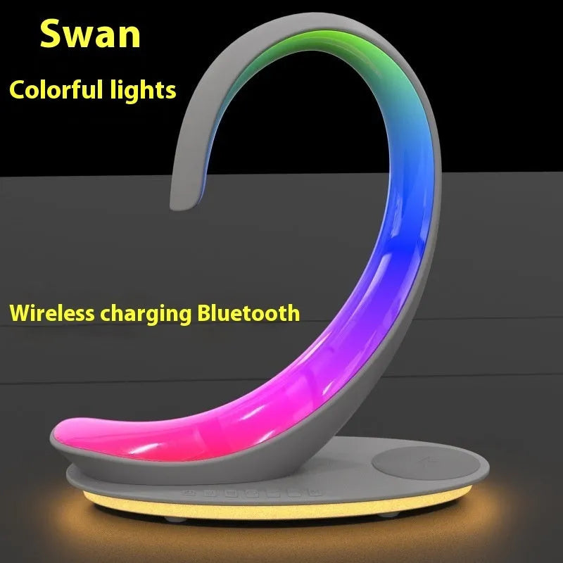 White swan-shaped desktop LED lamp with wireless charging pad and Bluetooth speaker.