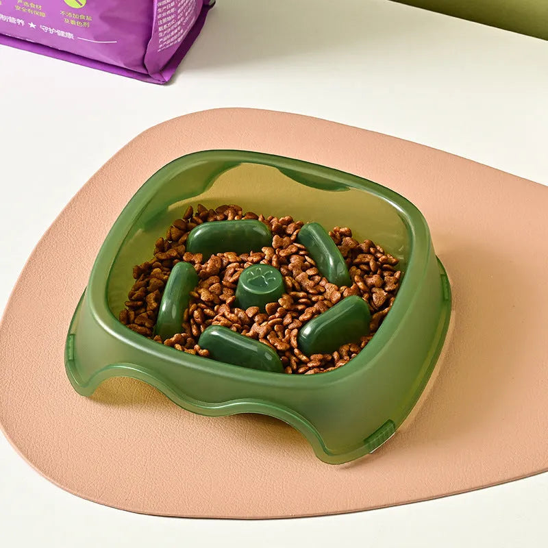 Blue plastic slow-feed dog bowl on a floor to prevent choking.