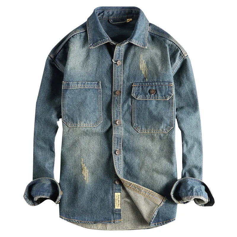 Man wearing a light blue vintage washed denim shirt with a loose fit and long sleeves.