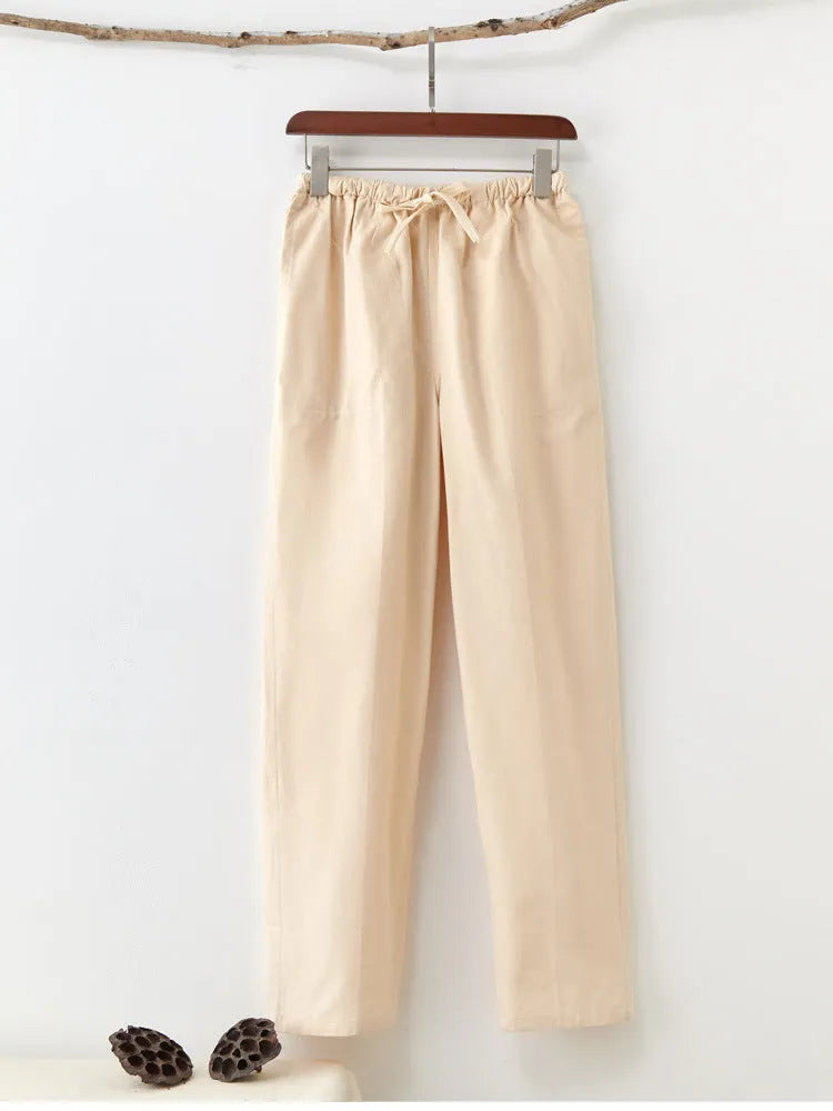 Men's beige pure cotton casual trousers with drawstring waist and belt on a neutral background.