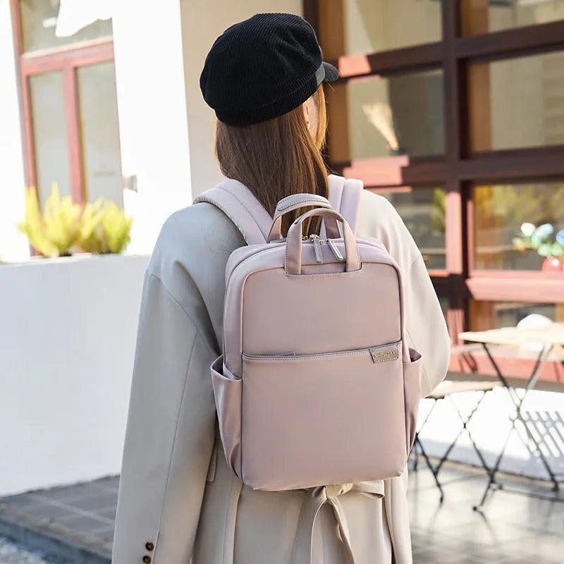 Women's nylon travel backpack showing laptop compartment and multiple internal organisers in apricot colour