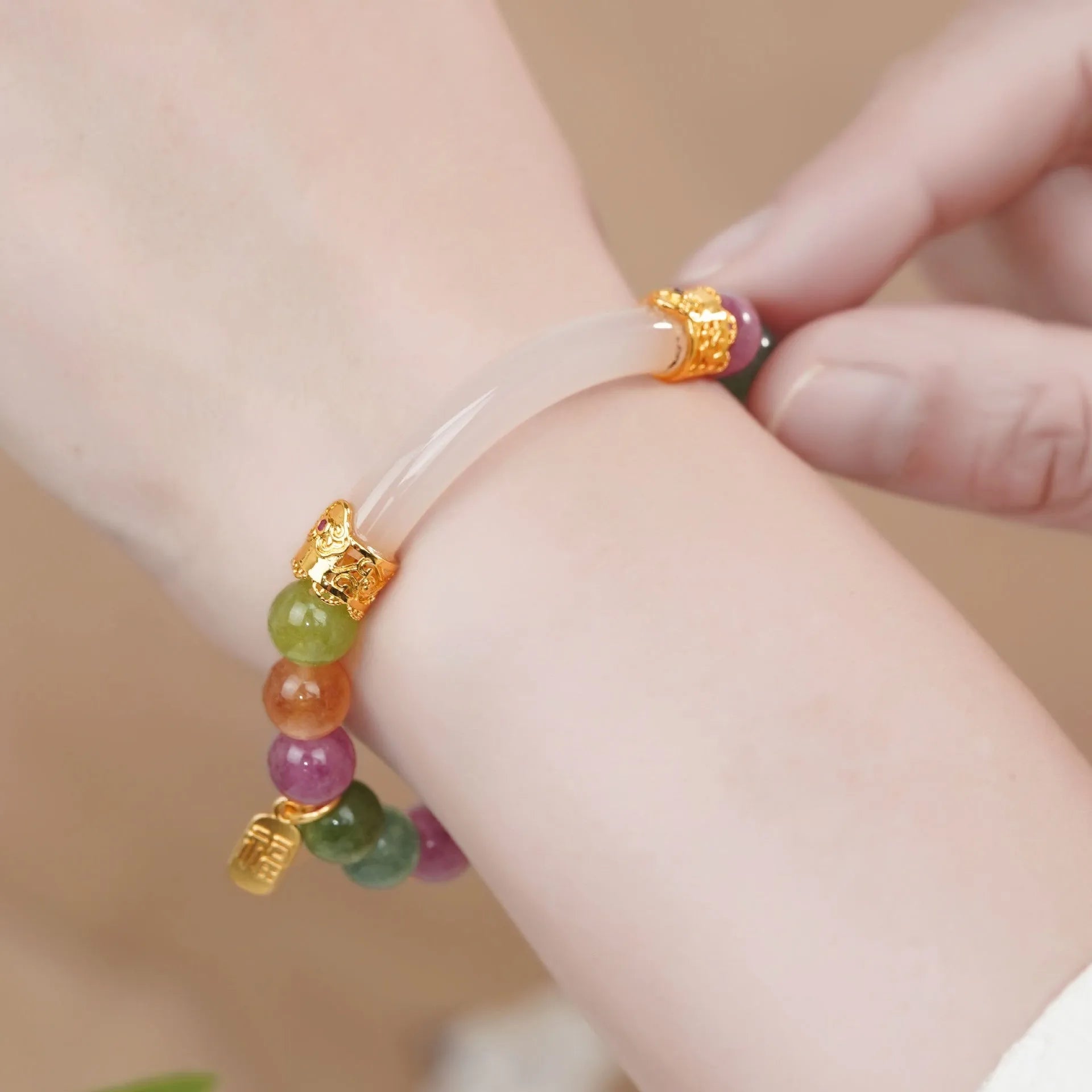 Women's rainbow tourmaline half bracelet with electroplated finish showing natural stone colour variations