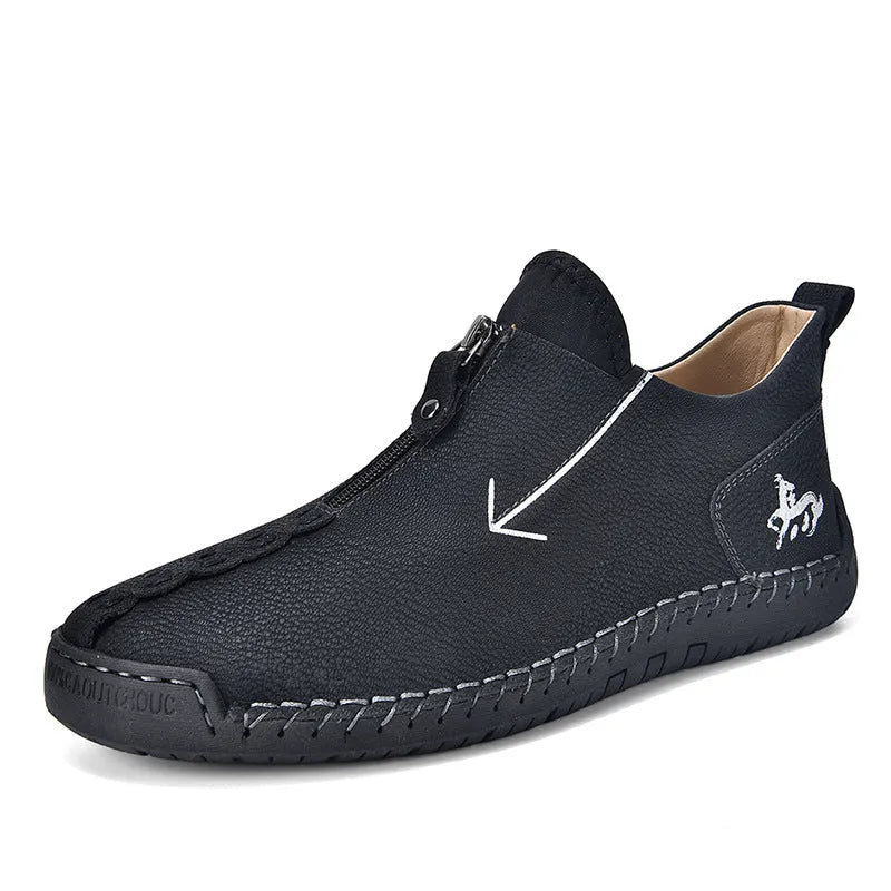 Men's black leather ankle boots with a front zip and hand-stitched detailing on a rubber sole.