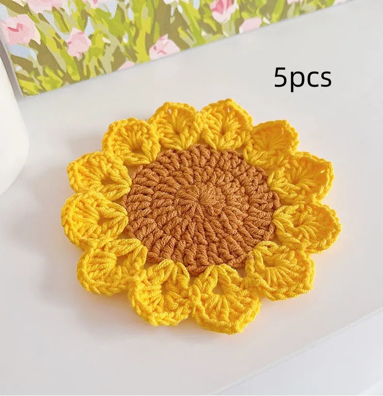 Hand-woven wool coaster set for drinkware on a tabletop.