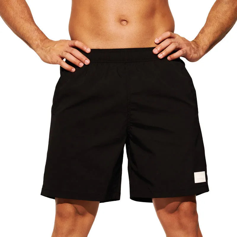 Men's solid colour quick-drying nylon sports shorts on a man, showing straight leg opening.