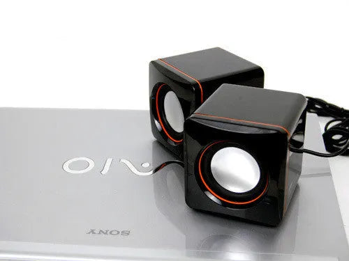 Small black square USB computer speaker model 700B on a desk.