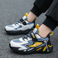 Boy's blue sports running shoe with velcro strap and mesh upper on a hard ground surface.