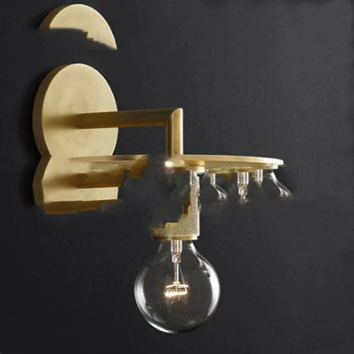 Gold bronze or black wall lamp with triangular transparent glass shade and wrought iron frame for bedside or hallway use