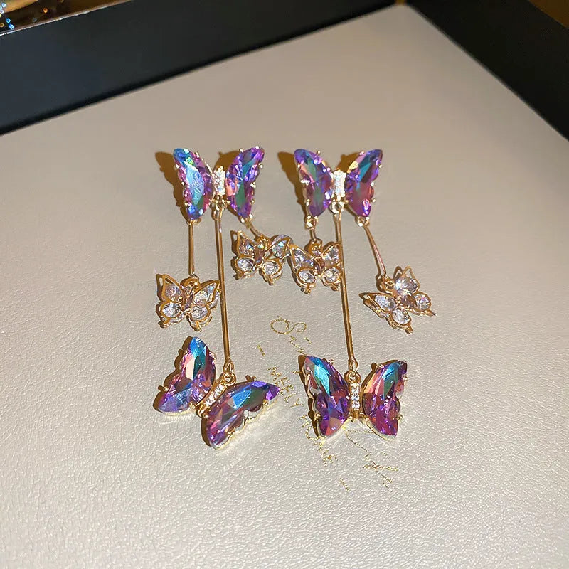 Silver Needle Crystal Flowers Blue Purple Butterfly Tassel Drop Earrings on a white background.