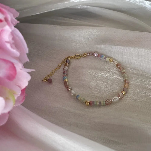 A women's bracelet and necklace set with irregular natural pearls and a 14K gilded purple finish.
