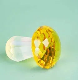 Solid resin crystal mushroom decoration in light green on a wooden surface