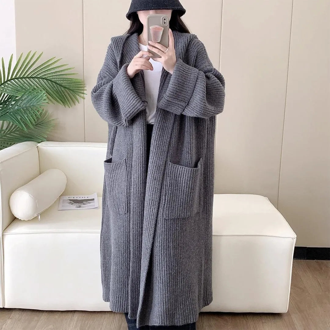 A woman wearing a loose, milky white hooded cardigan coat with raglan sleeves.