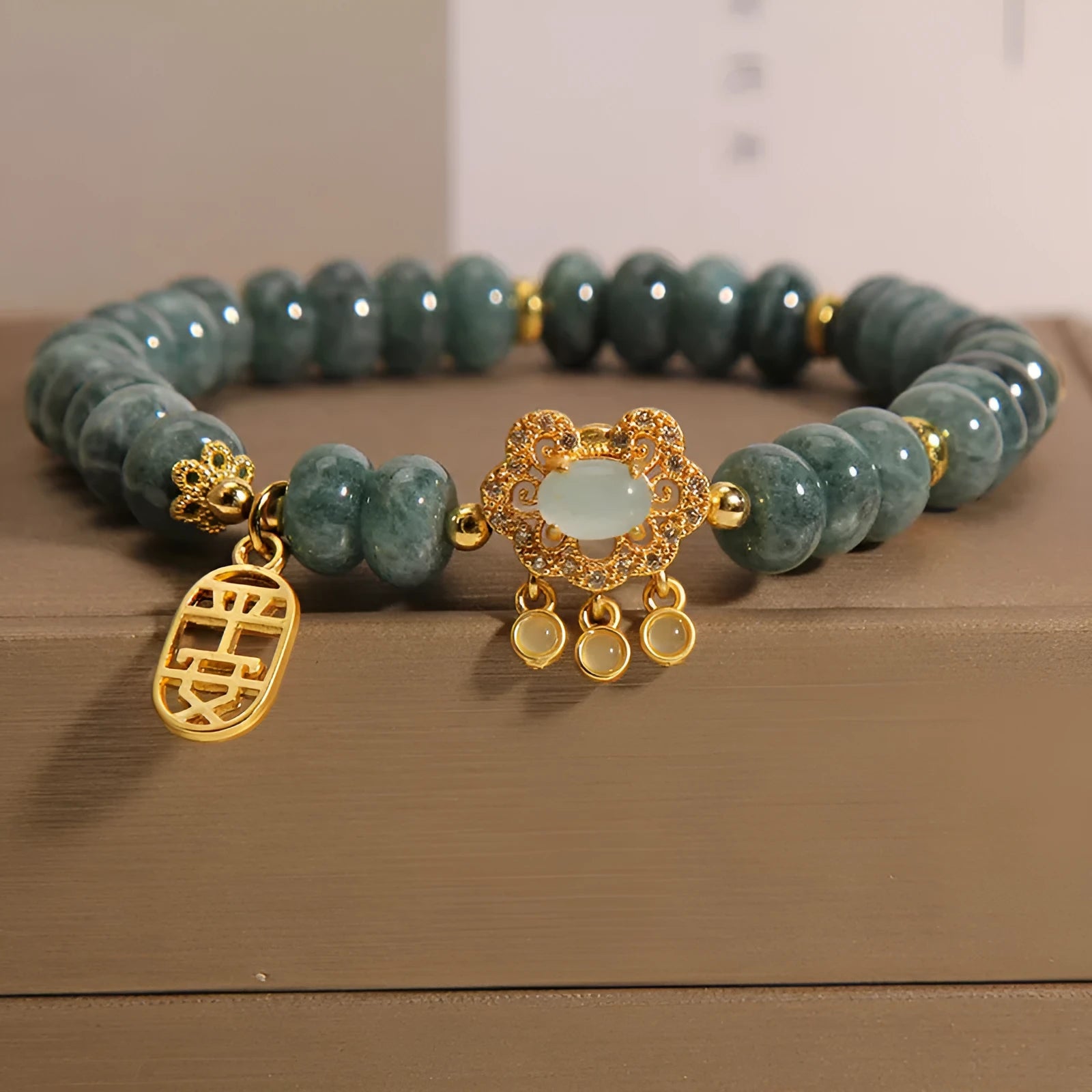 Close-up of a women's bracelet with green emerald jade and silver alloy abacus beads and a safety lock clasp.