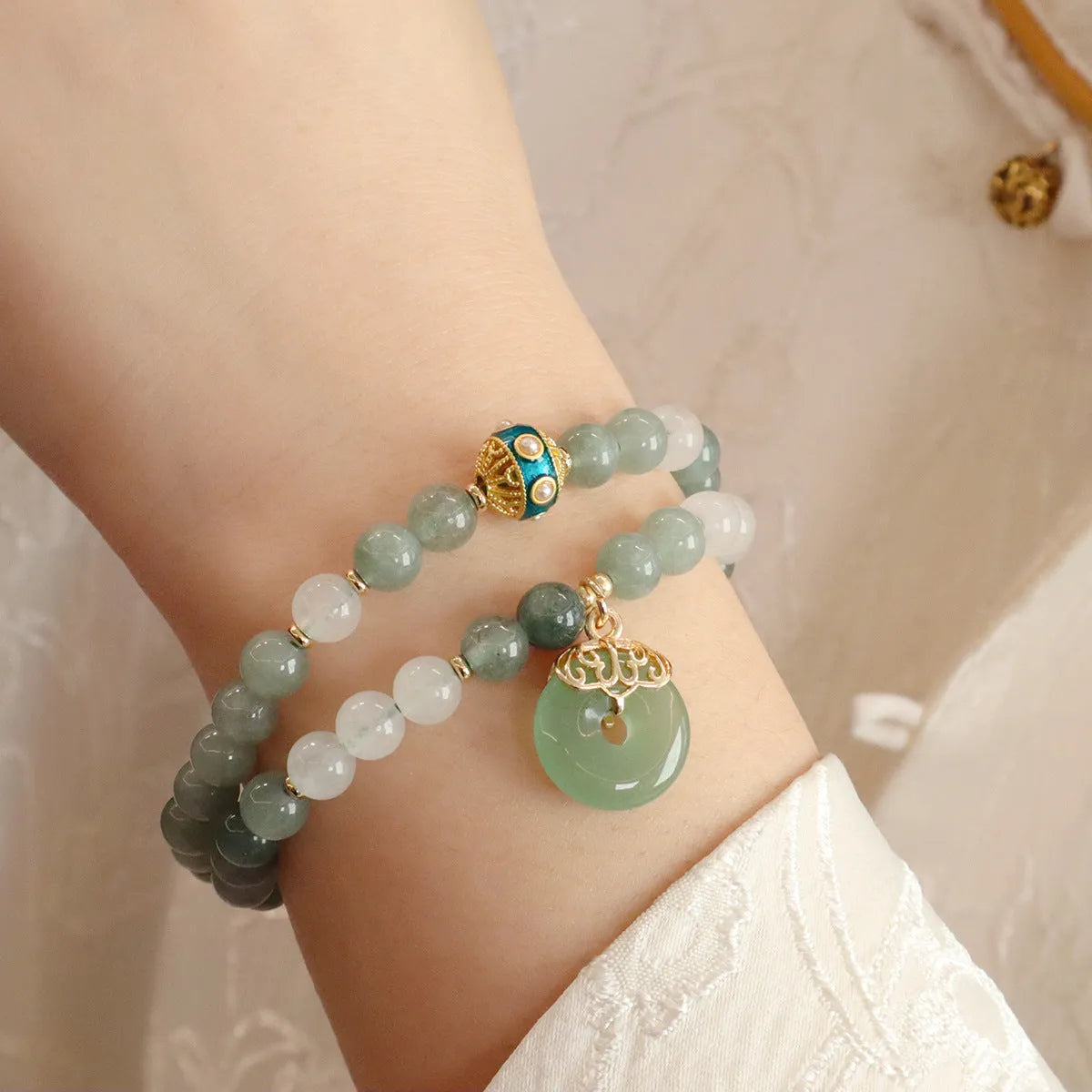 Women's bracelet with a silver peace buckle pendant and green Myanmar jade beads on a black cord.