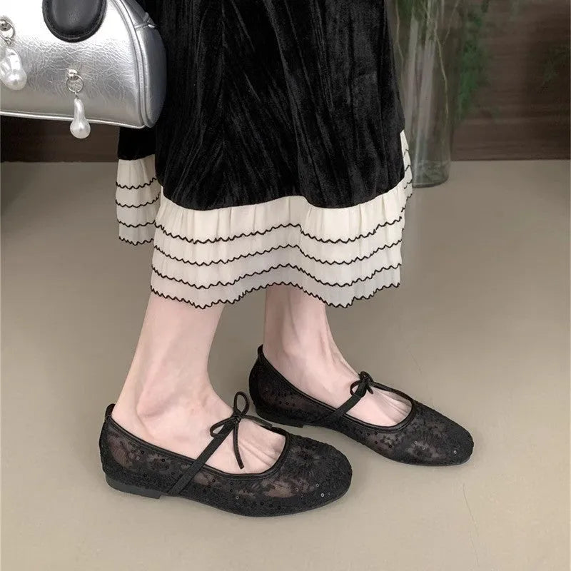 Pink flat heel Mary Jane evening shoes with lace mesh upper and rubber sole.
