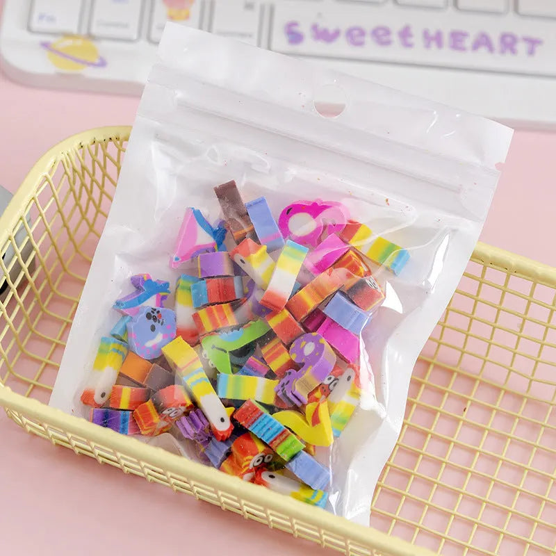 Sealed plastic bag containing 50 small cartoon-themed erasers in shapes like fruits, animals, and Christmas symbols.