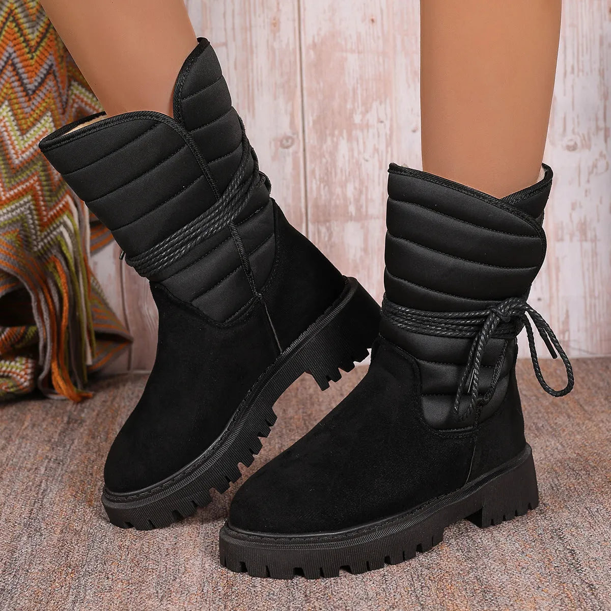 Women's black chunky heel snow boots with lace-up design and fleece lining on a high-top suede upper.