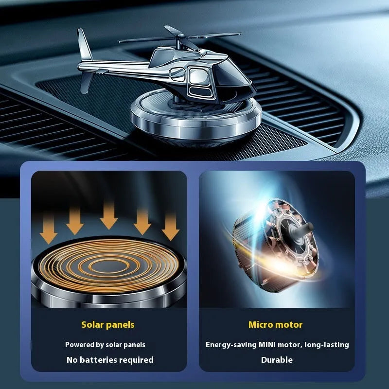 Silver metal solar-powered helicopter car air freshener rotating on a dashboard