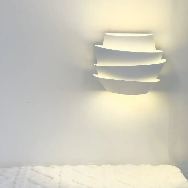 White modern wall lamp with pine cone silhouette design for bedroom or hallway lighting