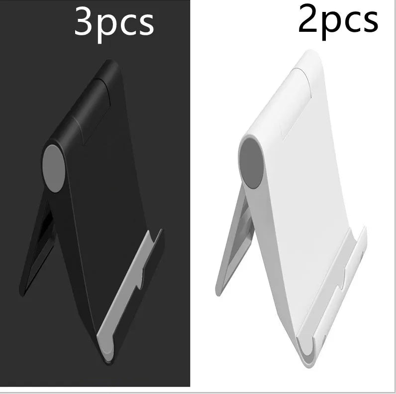 Black PE folding tablet stand holding a mobile phone at an adjustable viewing angle on a wooden desk.