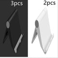 Black PE folding tablet stand holding a mobile phone at an adjustable viewing angle on a wooden desk.