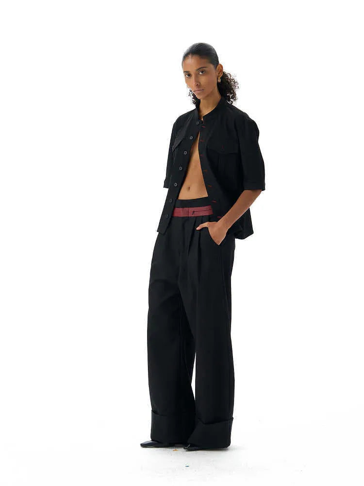A black loose fit half sleeve hunting shirt with a shirt collar on a hanger.