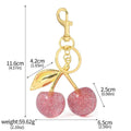 Close-up of a red zinc alloy keychain pendant with a three-dimensional cherry design.