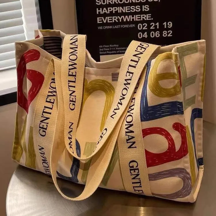 Large canvas women's tote bag with printed design, shown in available colour options.