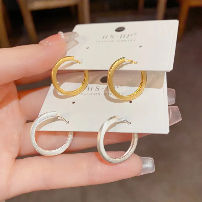 Geometric round women's ear clip with eyelet detail in gold or silver finish