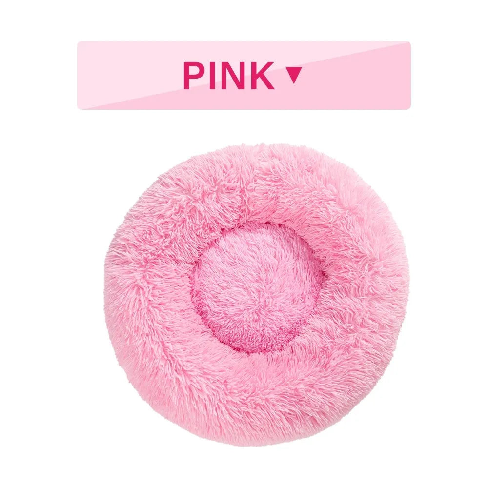 Fluffy grey donut-shaped dog bed with high plush sides on a wooden floor.