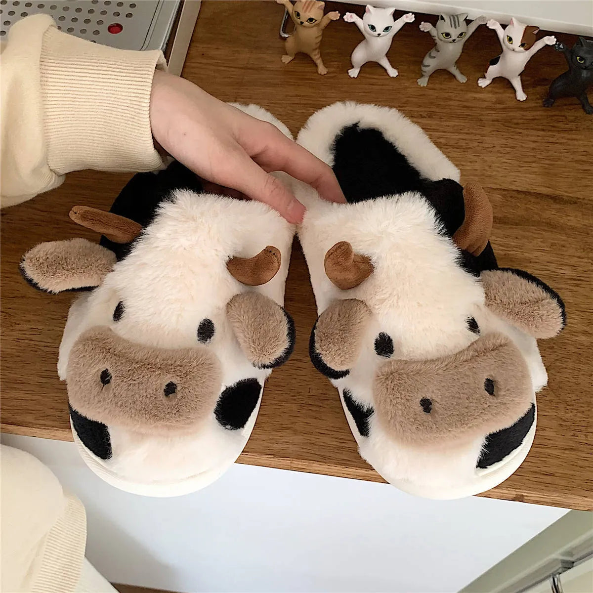 White women's cow slippers with fluffy faux fur, cartoon face, and textured non-slip sole.
