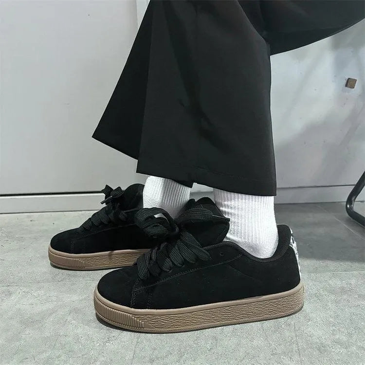 Retro black low-top sneakers on a waterproof platform sole with round toe and lace-up front.