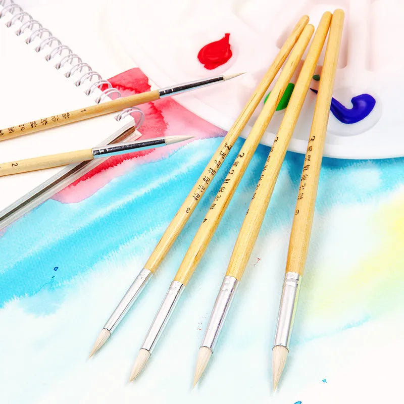 Six wooden hook line pen brushes with pointed handles and fine brush nibs arranged as a set