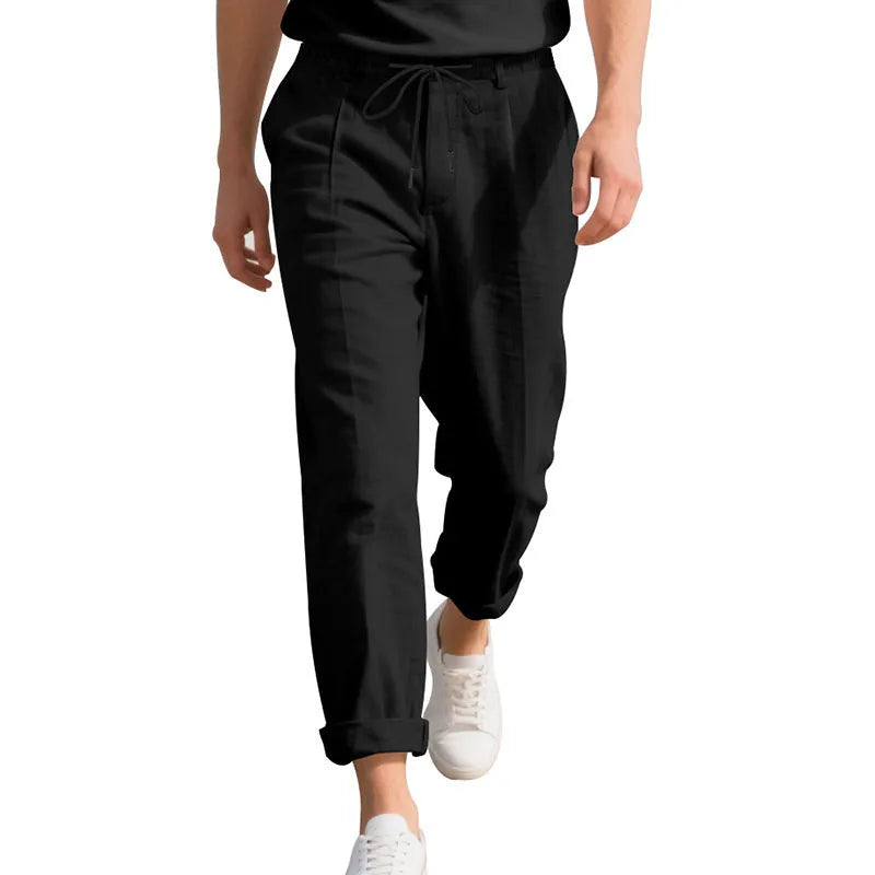 Man wearing light khaki linen casual trousers with a drawstring waist and straight-leg fit.