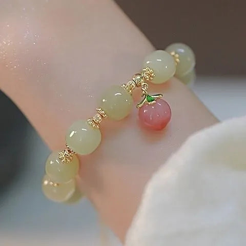Manual crafted glass and coloured glaze bracelet with rabbit charm and silver peace buckle clasp on wrist.