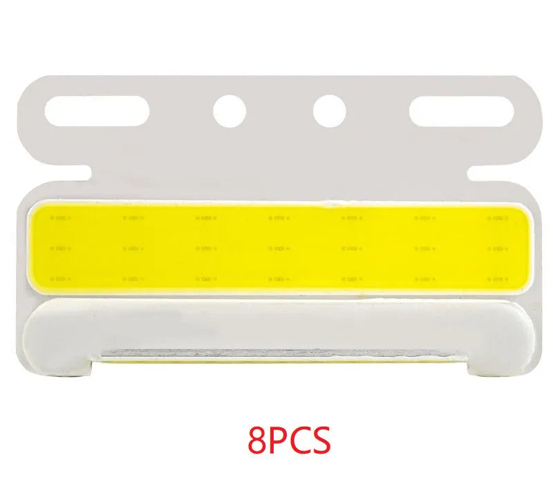 Aluminium alloy COB LED truck side light projecting bright white light onto ground next to tyre.