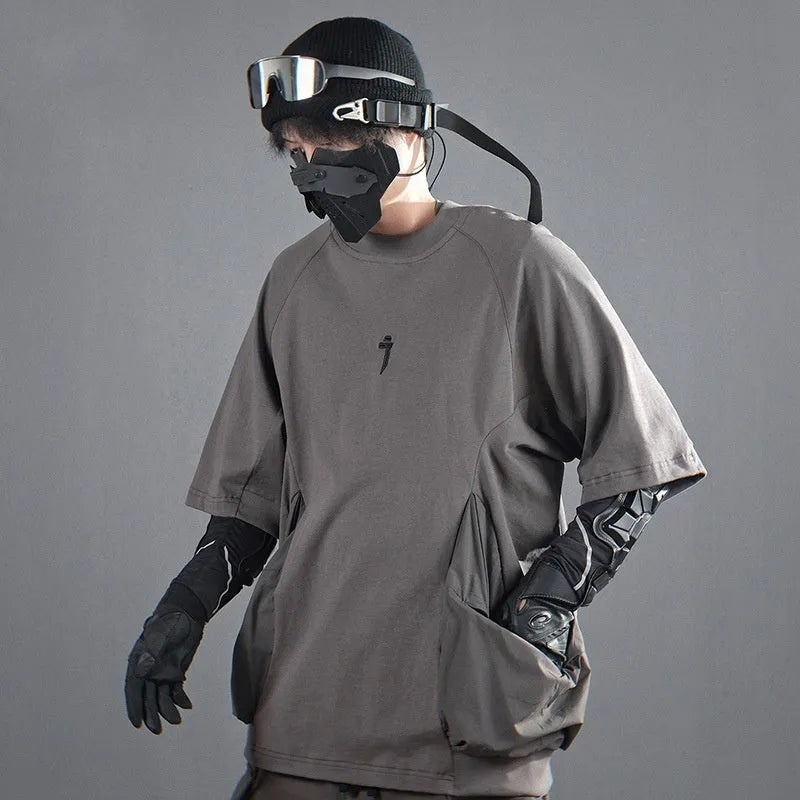 A man's loose black cotton T-shirt with large chest pockets and short sleeves.