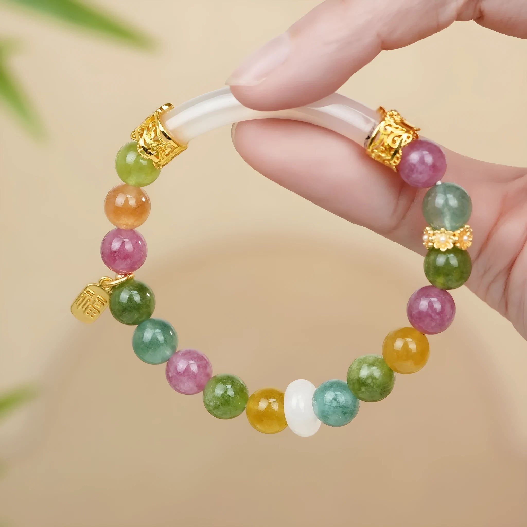 Women's rainbow tourmaline half bracelet with electroplated finish showing natural stone colour variations