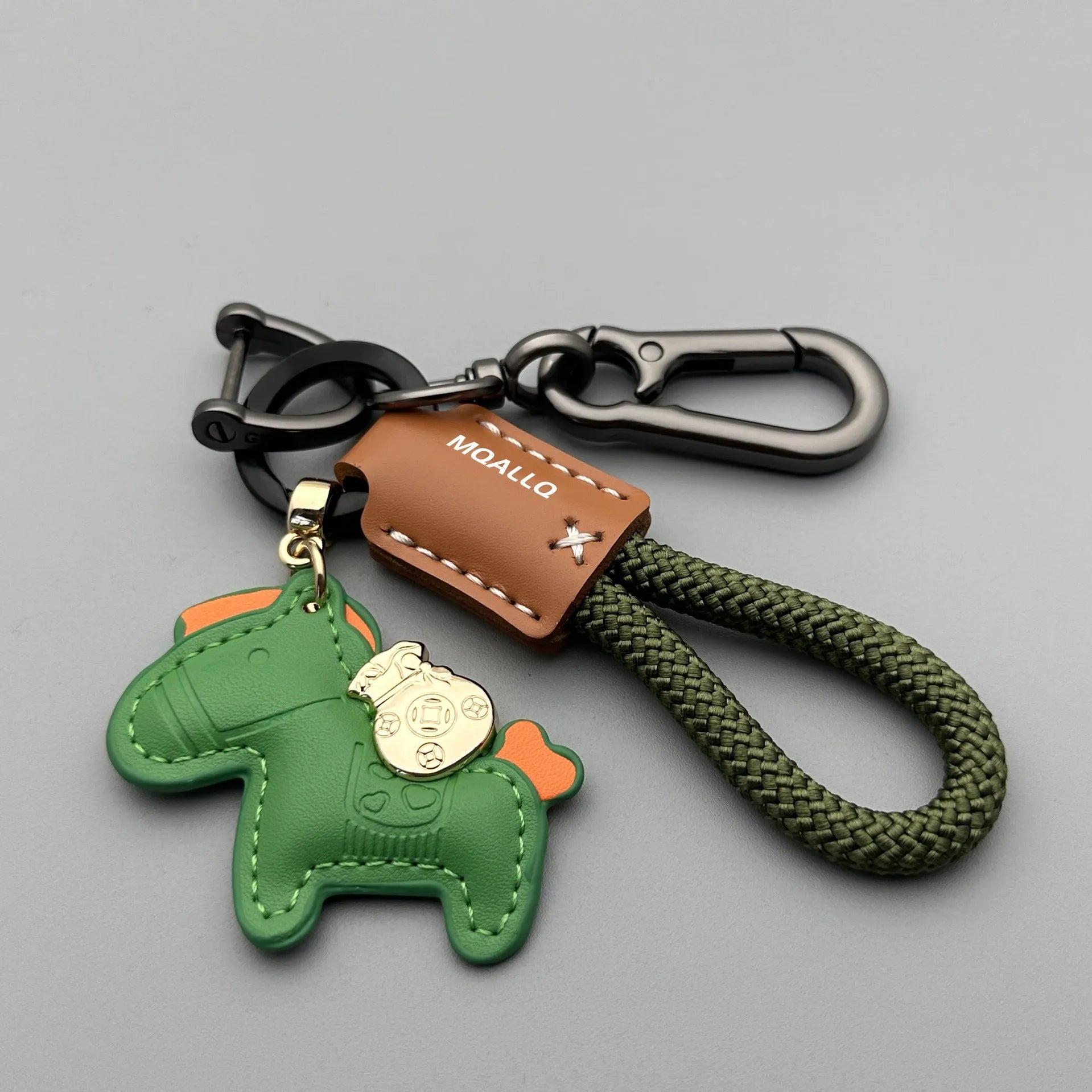 Handmade brown cowhide leather key ring with a zinc alloy pendant charm on a green flannel rope.
