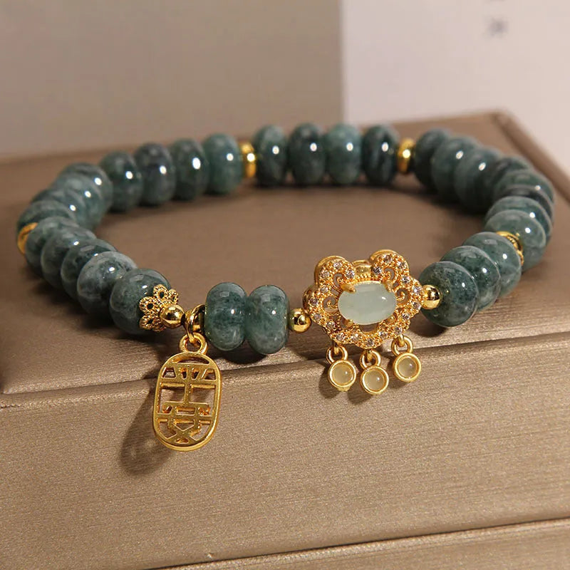 Close-up of a women's bracelet with green emerald jade and silver alloy abacus beads and a safety lock clasp.