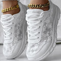 Women's white canvas running shoes with a soft flat sole on a plain background.
