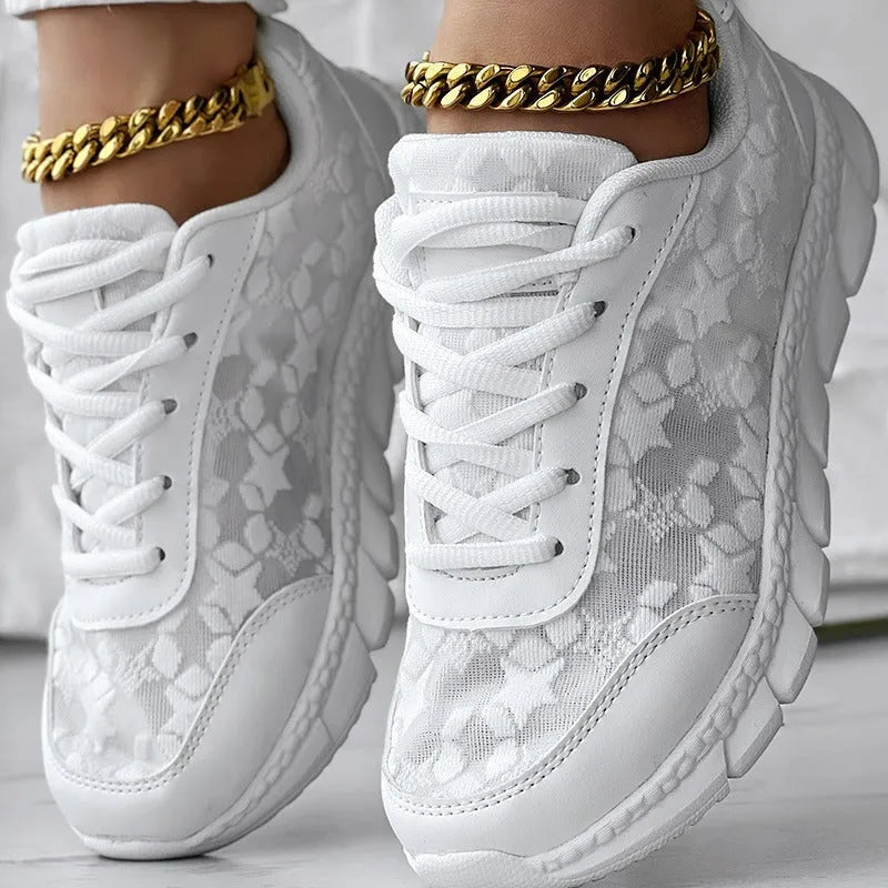 Women's white canvas running shoes with a soft flat sole on a plain background.