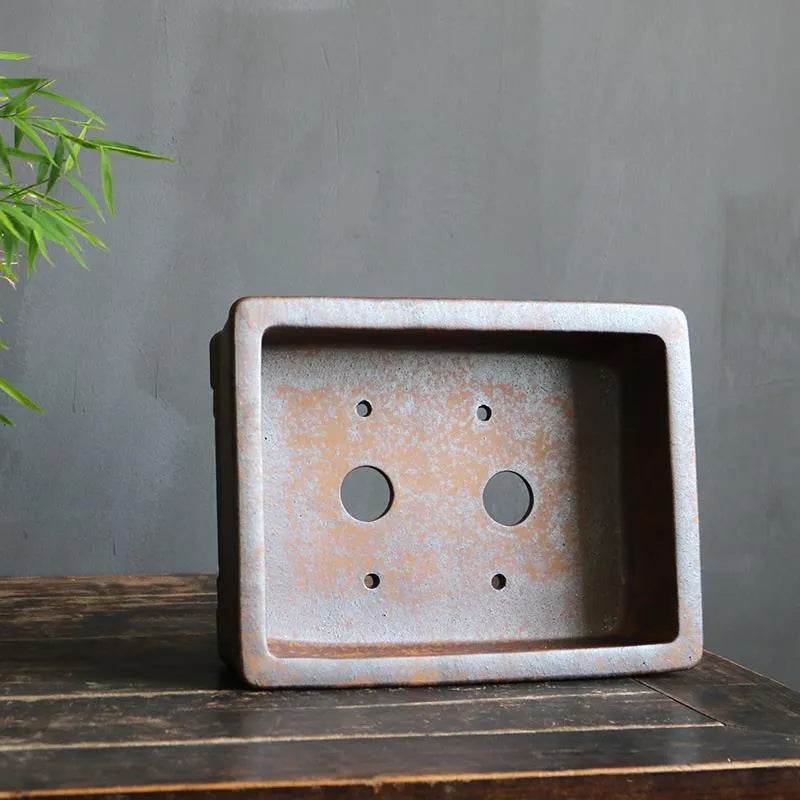 Handmade rectangular purple sand bonsai pot with natural firewood-burnt glaze, shown empty on a wooden surface.