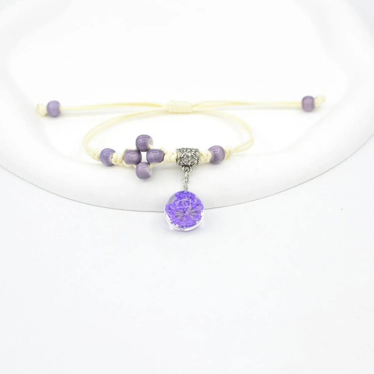 Hand-woven glass bracelet with large beads containing real dried flowers, shown in multiple colour options.