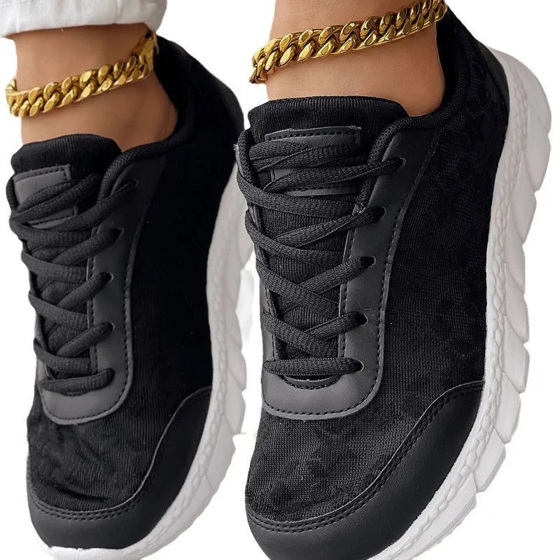 Women's white canvas running shoes with a soft flat sole on a plain background.