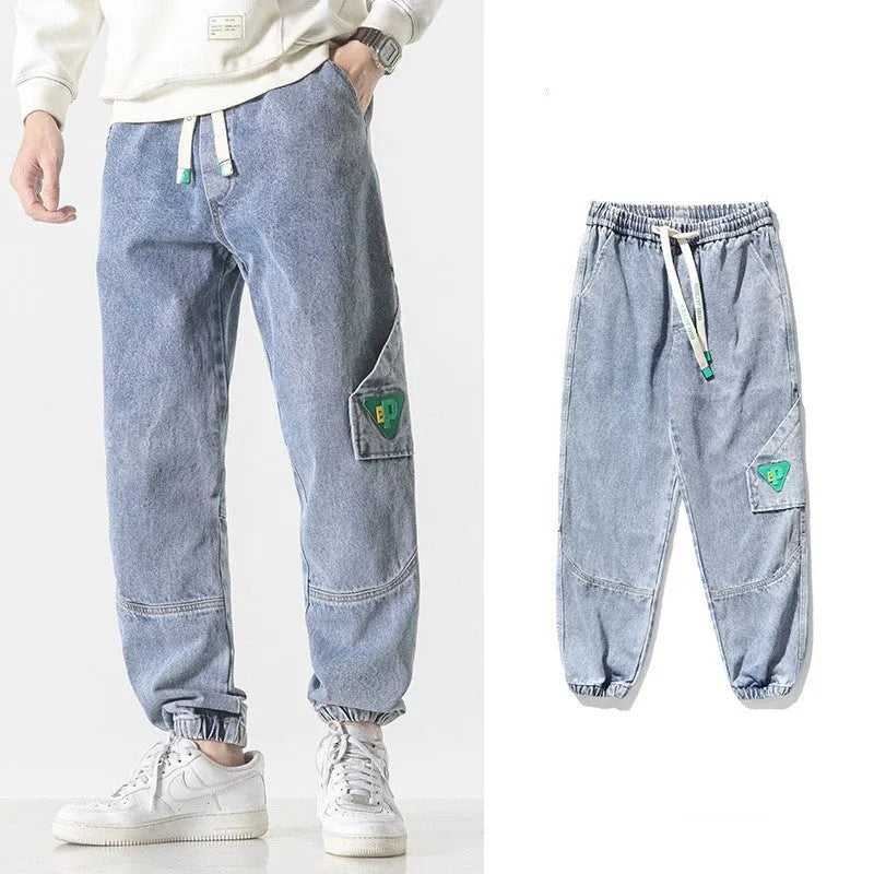 Men's loose-fit tapered cotton trousers in grey colour, shown on a model.