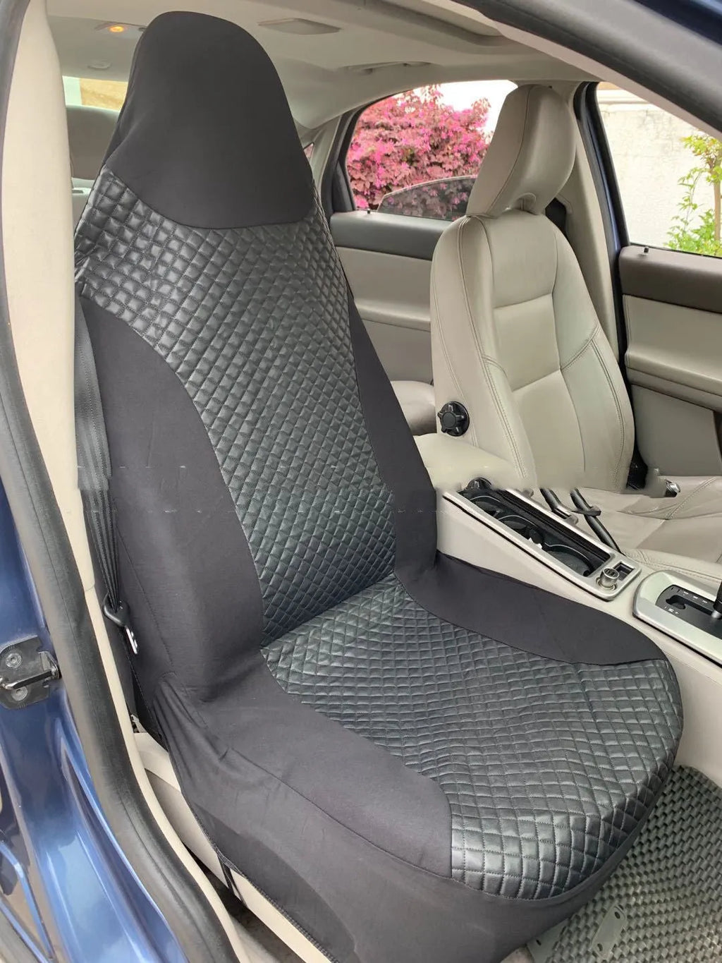Black quilted automotive seat cover made of PU and polyester fabric on a car seat.