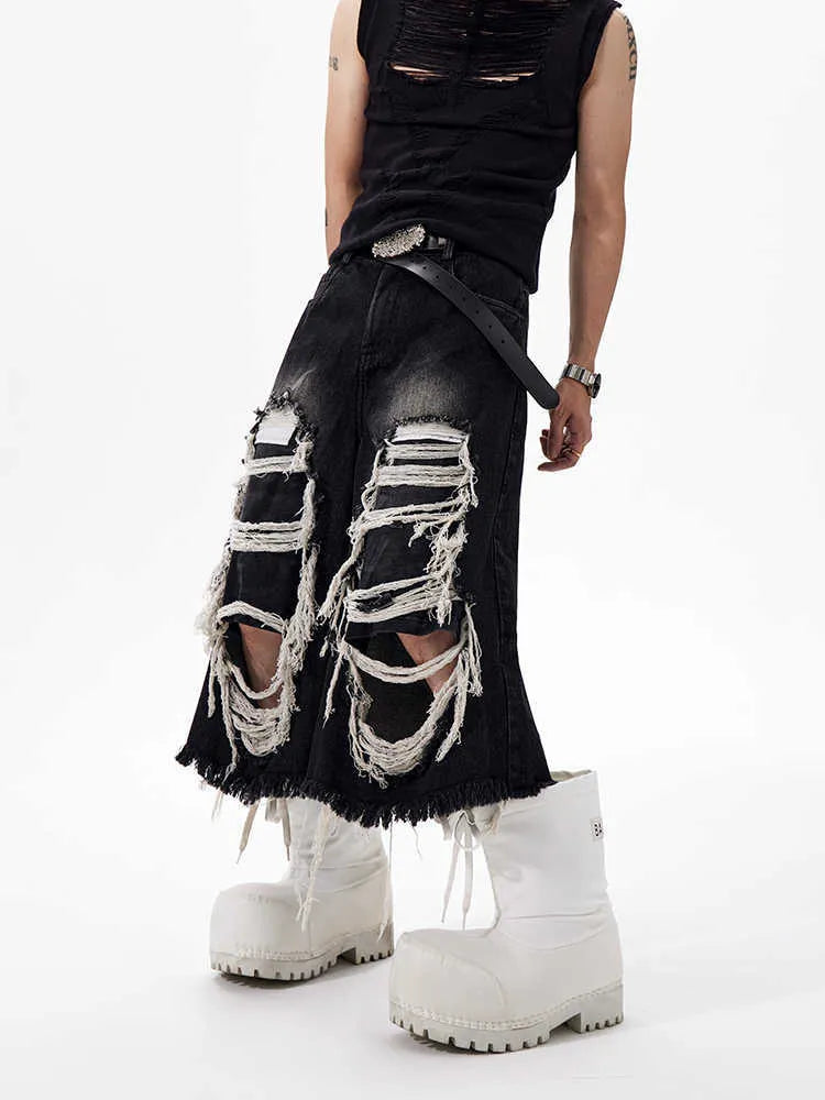 Black wide-leg cropped jeans with a ripped patch detail on the leg, shown on a model.