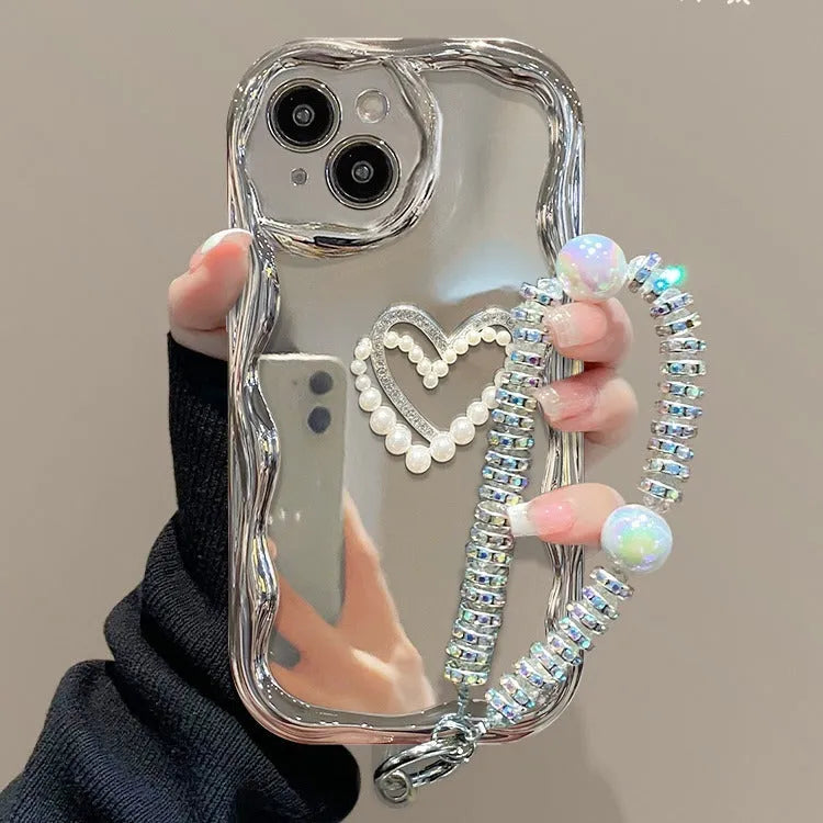 Silver grey silicone phone case for iPhone 14 Pro Max with three-dimensional heart and pearl chain bracelet.