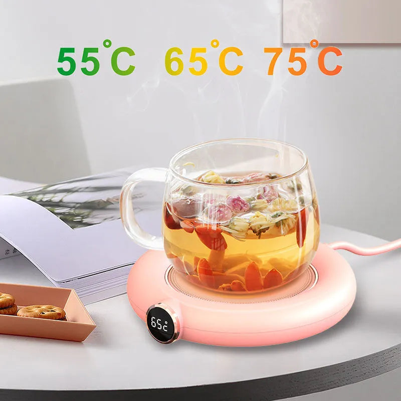 White USB cup warmer pad with LED display on a desk next to a coffee mug.